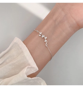 Detailed view of silver ginkgo leaf bracelet on wrist with elegant minimalist design