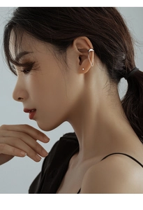 Close-up of a 925 silver chain ear cuff and stud earring on a female model