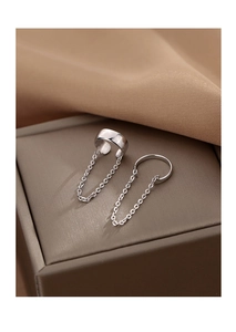 Detail of silver chain ear cuff set with smooth metal texture on jewelry box