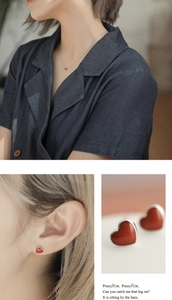 Detail showing red heart earrings and necklace set worn by a model in a close-up macro view