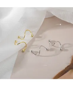 Detailed view of silver and gold spiral stud earrings with polished metal beads on top