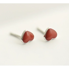 Detail of red heart-shaped S925 sterling silver earrings with polished metallic edges