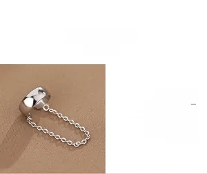 Detail of 925 sterling silver ear cuff with chain featuring polished metallic texture