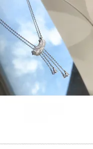 Gros plan du collier pendentif plume étincelant avec glands en zircon sur ciel bleu