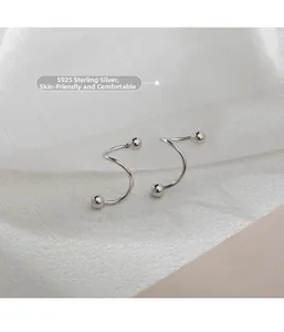 Close-up of S925 sterling silver spiral earrings with smooth bead ends on white fabric
