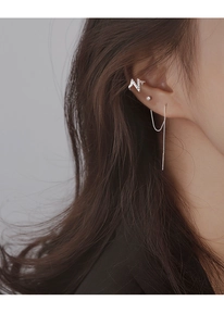 Close-up of silver chain tassel earrings and N-shaped zircon ear cuff on a model's ear