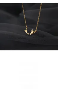 Detail of a double butterfly pendant necklace in gold finish with sparkling zircons