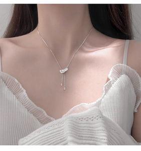 Gros plan sur un pendentif plume étincelant avec de longues franges et gouttes d'eau