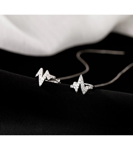 Macro shot of silver heartbeat earring encrusted with sparkling cubic zirconia stones