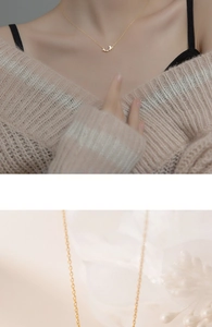 Close-up of minimalist gold butterfly necklace worn by a model with knit sweater