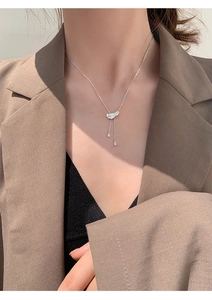 Détail du collier plume argentée avec pampilles en cristal porté par un mannequin femme
