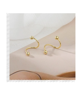 Detailed view of polished golden S-shape spiral stud earrings with elegant ball ends