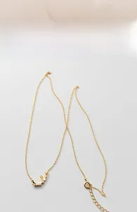 Close-up of golden butterfly pendant with small zircon stones and elegant link chain
