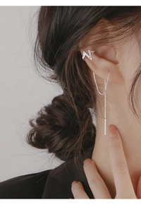Detail of silver lightning bolt ear cuff with sparkling zircon and long chain earring