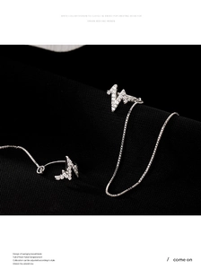 Detail view of heartbeat line silver ear cuff with sparkling zircons and fine link chain