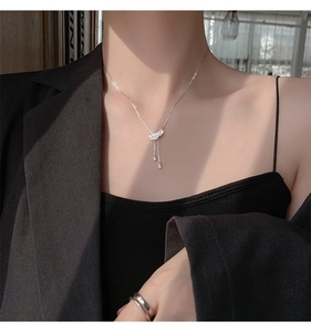 Vue détaillée du collier pendentif plume étincelant avec d'élégantes gouttes sur un mannequin