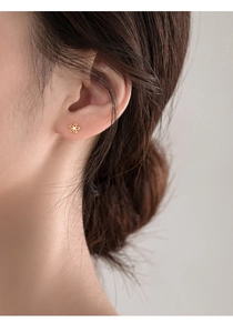 Close-up of a 925 sterling silver gold flower stud earring with a central zircon stone
