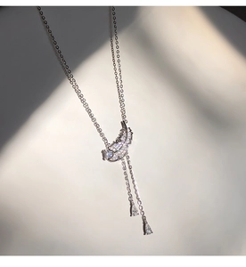 Détail macro du pendentif plume avec zircons et cristaux en forme de goutte d'eau
