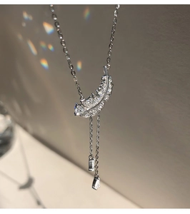 Détail du pendentif plume scintillant avec de longues franges et gouttes en cristal