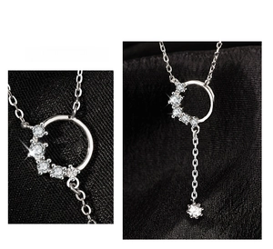Macro shot of silver ring pendant with zircon inlay and fringe detail on black silk