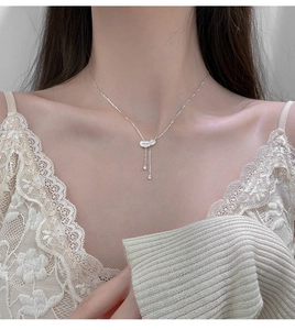 Collier plume argenté avec pampilles goutte d'eau porté par un mannequin en dentelle