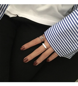 Detail of minimalist silver S925 rings with interwoven and geometric square plate designs