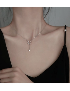 Detail of silver circle necklace with tassel and small star pendant on model