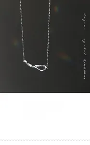 Detailed close-up of infinite Mobius ring necklace with shimmering zircon stones