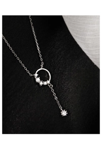 Macro shot of silver ring pendant with sparkling diamonds on textured black fabric background