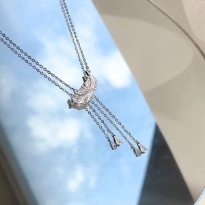 Collier élégant pendentif plume avec cristaux étincelants et glands sur fond miroir