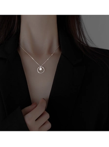 Elegant silver circle necklace with white pearl pendant worn on a professional outfit