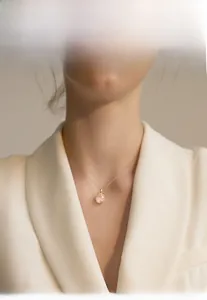 Close-up of model wearing S925 silver lucky cat necklace with pink chalcedony pendant