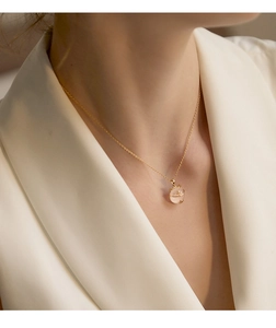 Close-up of a s925 silver cat necklace with a pink gemstone pendant on a woman neck