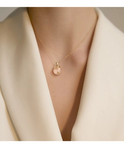 Close-up of S925 silver lucky cat necklace with pink chalcedony pendant on model