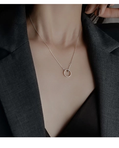 Détail du collier lariat cercle minimaliste en argent sterling 925 sur un blazer gris