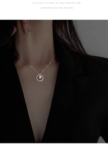 Detail view of a minimalist S925 silver circle pearl necklace on a model