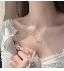 Close-up of minimalist infinity pendant necklace with micro-pave diamonds on silver chain