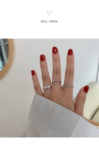 Detailed view of a three-piece silver heart ring set on a hand for styling inspiration