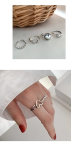 Macro detail of vintage silver heart ring set on white cloth and model hand