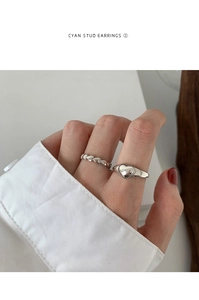 Detail showing polished silver-finish heart signet ring and heart band set worn on hand