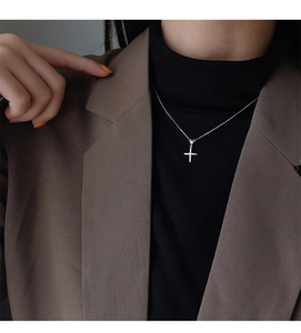 Gros plan d'un collier pendentif croix argenté étincelant sur un mannequin