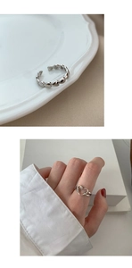 Detailed macro shot of vintage silver open rings with hollow heart designs and metallic texture