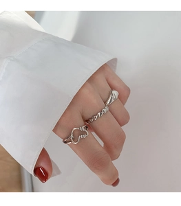 Detailed macro view of a vintage silver heart ring set with polished stackable designs