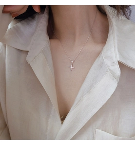 Gros plan d'un collier pendentif croix minimaliste en argent serti de zircons brillants