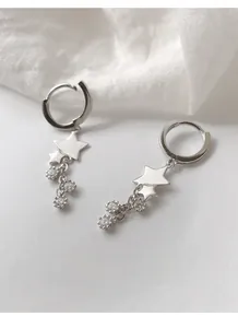 Détail de boucles d'oreilles étoiles en argent avec pampilles et zircons brillants