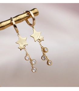Détail de la boucle d'oreille étoile avec franges dorées et trois zircons brillants