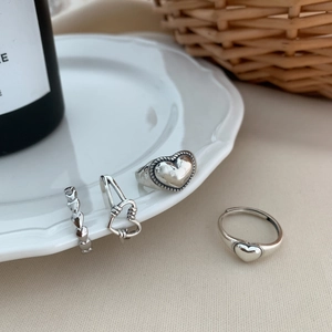 Set of four vintage silver heart rings featuring solid and open heart designs for women