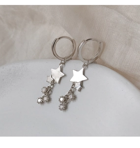 Détail de boucles d'oreilles étoile en argent avec pompons brillants en zircon