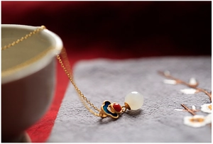 Dettaglio del ciondolo in argento 925 placcato oro con giada Hetian e smalto blu floreale
