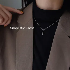 Collier croix en argent S925 avec zircons porté sur un pull à col roulé noir